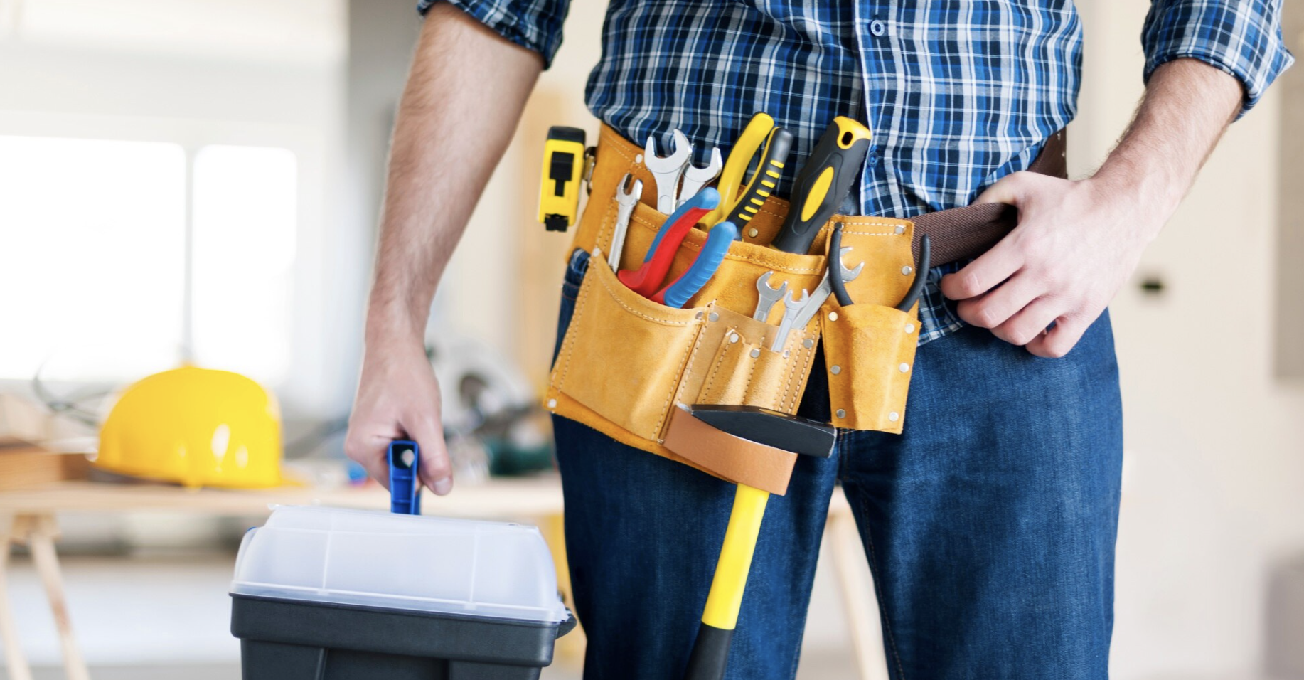 L'image représente un homme qui tient une malette de bricolage prêt à réparer quelque chose dans une maison.